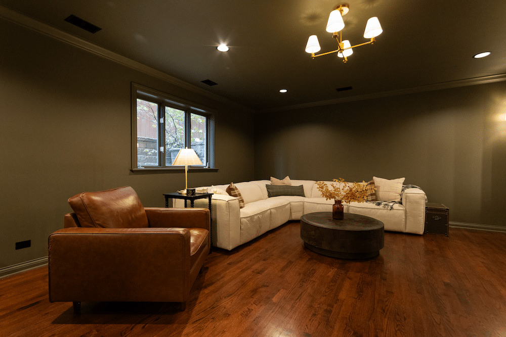 A luxury basement design with green walls, a green ceiling, and a white couch.