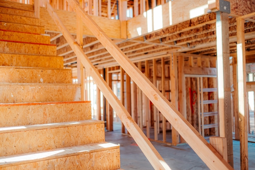 Wooden staircase under construction with an open framework in the background.