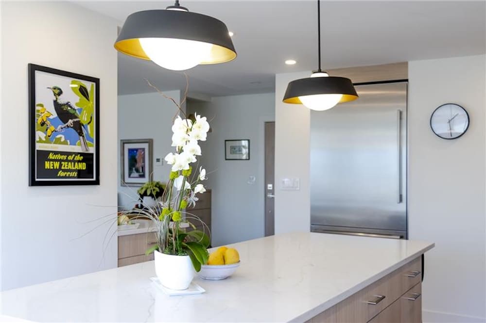 A modern kitchen with a marble island potted orchids and decorative lemons - Arete' A modern kitchen with a marble island potted orchids and decorative lemons